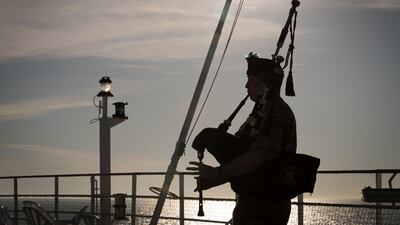 A military piper plays at a wreath laying ceremony.