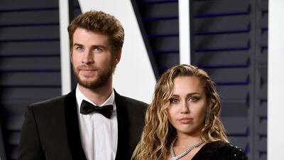 Liam Hemsworth and Miley Cyrus in Saint Laurent arrive at the 2019 Vanity Fair Oscar Party. AP