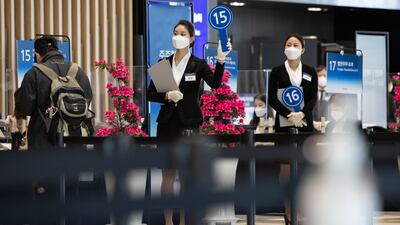 A member of event staff wearing a protective mask holds up a numbered paddle during the Samsung Electronics Co. annual general meeting at the Suwon Convention Center in Suwon, South Korea. Bloomberg