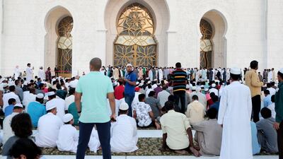 Men wait for the start of Eid prayers. Christopher Pike / The National