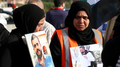 Family members of August 4 Beirut blast victims carry portraits of the deceased relatives, during a protest at the scene of the explosion, on May 4 2021. EPA