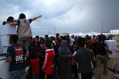 Syrian refugees wait to receive aid and food supplies at Bardarash refugee camp, south of Duhok in Iraqi Kurdistan, on October 21, 2019. EPA