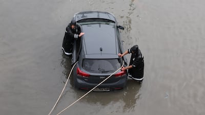 Civil Defence personnel help a motorist whose car is stuck in floodwater, in Tunisia's capital Tunis. EPA