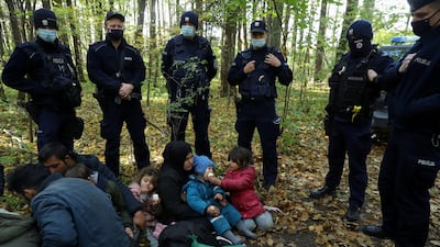 Migrants are surrounded by border guards after crossing from Belarus into Poland. Reuters