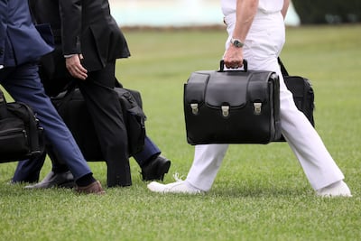 A military aide carries the so-called nuclear football as he walks to board the Marine One helicopter. Reuters