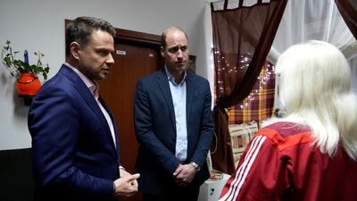Prince William and Mayor of Warsaw Rafal Trzaskowski talk to a Ukrainian woman at the accommodation centre. AP