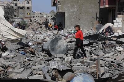 Palestinian youths salvage items from a destroyed house in eastern Gaza city following Israeli air strikes. AFP