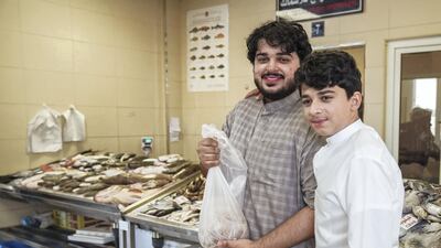 Omar and Ibrahim buy fish for their mother at the market.