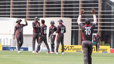 UAE players celebrate taking an Oman wicket during the Cricket World Cup League 2 match at the ICC Academy in Dubai.