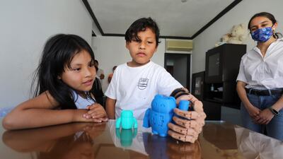 With his sister and two brothers looking on, Juan tried out his new limb for the first time in the family living room, slowly flexing at the elbow to close the hand. Reuters