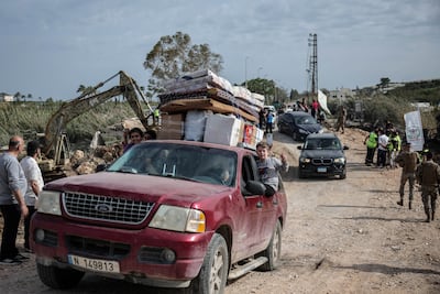 Children celebrate from a vehicle as displaced people return home. Reuters