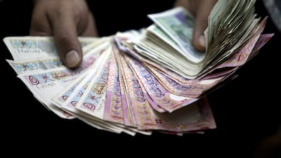 Oman’s rial currency is pegged to the dollar, but the cost of a taxi ride varies according to the driver. Silvia Razgova / The National