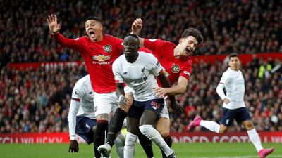 Manchester United's Harry Maguire and Marcos Rojo in action with Liverpool's Sadio Mane. Reuters