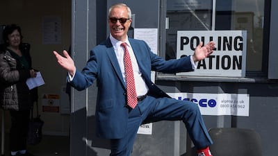 Reform UK leader Nigel Farage poses to show off his socks as he visits a polling station in Walton-on-the-Naze, eastern England on Thursday. AFP