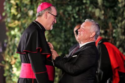 Jordan's King Abdullah II decorates Pierbattista Pizzaballa with an honour commemorating Jordan's 76th Independence Day. (Khalil MAZRAAWI/ AFP)
