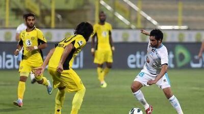 Ahmed Ibrahim of Al Wasl, left, sets to defend his space from Saleh Hamad of Baniyas.