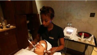 A client undergoes the K-Lift facial at Raffles Spa in Dubai. The therapist uses bright red LED lights during the facial.