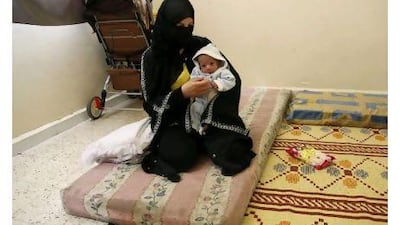 A Syrian refugee woman holds her three-week-old baby, who was born in Lebanon, as she sits on a mattress in an abandoned school where food and shelter are provided by a local charity, in Wadi Khaled area, northern Lebanon. Mohammed Azakir / Reuters