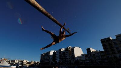 A competitor falls off the gostra, a wooden pole covered in lard, during the celebrations for the religious feast of St Julian, patron of the town of St Julian's, in Malta. Reuters