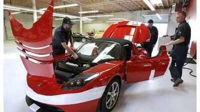 Workers assemble a Tesla Roadster in California. The car maker has posted losses in every quarter since its founding in July 2003.