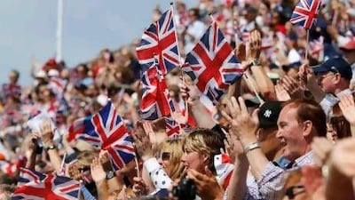 Fans wave Union Jacks during an equestrian individual dressage event in Greenwich Park.
