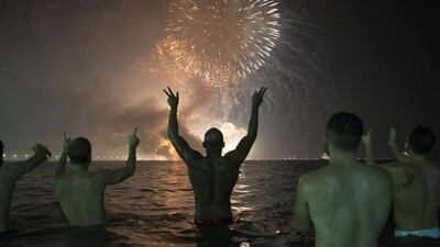 People watch the fireworks exploding over Copacabana beach in Rio de Janeiro. Leo Correa / AP Photo