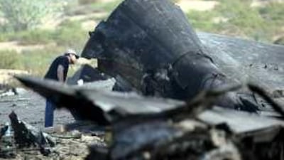 A crash investigator inspects the burnt out tail section of the Azza Air Transport aircraft.