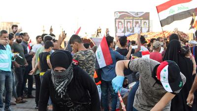 Volunteers clean the site of the protest near the Basra provincial council building during protests in the city. AP
