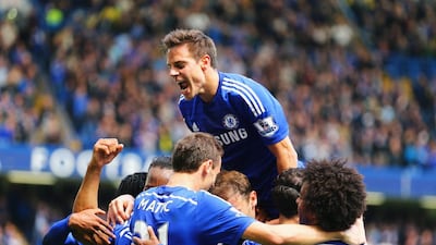 Cesar Azpilicueta of Chelsea, top, and teammates mob Eden Hazard after he scores their first goal during their Premier League match against Crystal Palace at Stamford Bridge on Sunday. Clive Mason / Getty Images