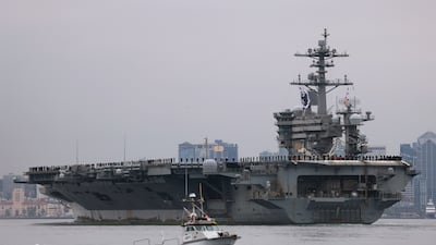 US Navy sailors line the deck of the USS Theodore Roosevelt aircraft carrier as it returns to its San Diego homeport after a nine-month deployment in 2024. Getty Images