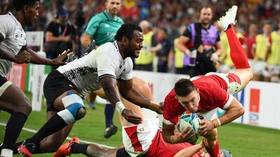 Wales' wing Joshua Adams (R) scores a try past Fiji's scrum-half Frank Lomani (L) and Fiji's full back Kini Murimurivalu during the Japan 2019 Rugby World Cup Pool D match between Wales and Fiji at the Oita Stadium in Oita. AFP