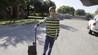 Ahmed Mohamed, 14, grabs a suitcase as he arrives to his family's home in Irving, Texas. Ahmed Mohamed was arrested at his school after a teacher thought a homemade clock he built was a bomb. (AP Photo/LM Otero)