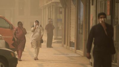 Workers brave the sandstorm in Abu Dhabi as they walked along Hamdan Street covering their mouths from the visible dust particles that plastered the morning commuters. Delores Johnson / The National