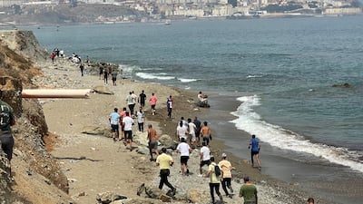 Migrants travel along the coast on foot as they attempt to cross into the North African enclave from Morocco. Reuters