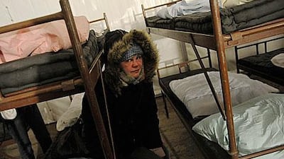 A homeless woman sits inside a large tent set up as a shelter in Prague, the Czech capital, during severe weather that has killed over 150 people across Europee.