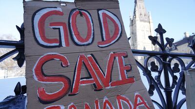 A sign reads 'God Save Canada' on the fence surrounding Canada's Parliament building. Willy Lowry / The National