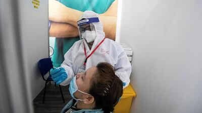 A medic testing a commuter for Covid-19. Antonie Robertson / The National