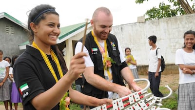 Dubai Cares country programme manager Mada Al Suwaidi, left, and public relations officer Bahaa Hamade receive a rousing welcome by the Serafin C. Rosero Memorial High School band. Photo courtesy of Dubai Cares