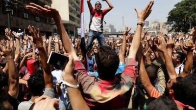 Supporters of Mohammed Morsi chant slogans against Egypt's military before clashes broke out in Cairo on Friday. Hassan Ammar / AP Photo