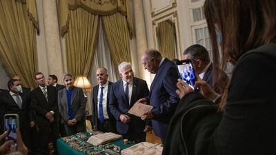Mr Lapid presents Mr Shoukry with stolen Egyptian artefacts that were smuggled to Israel, at Tahrir Palace in Cairo. AP