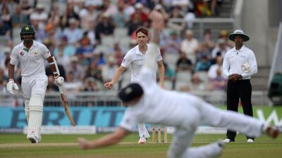 England's Chris Woakes, centre, looks on as England's Ben Stokes fails to stop a drive from Pakistan's captain Misbah-ul-Haq on the third day of the second Test between England and Pakistan at Old Trafford in Manchester, northwest England, on July 24, 2016. Oli Scarff / AFP