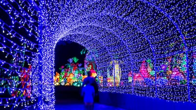 Visitors are surrounded by light as they walk through dazzling arches