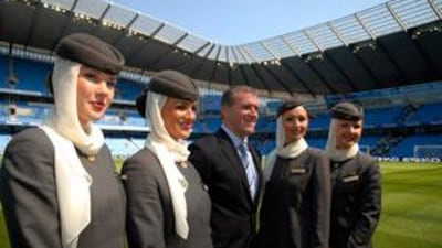 The Manchester City chief executive Garry Cook is flanked by Etihad air-hostess' as the club announces a new three year sponsorship deal with the Abu Dhabi based air-line.