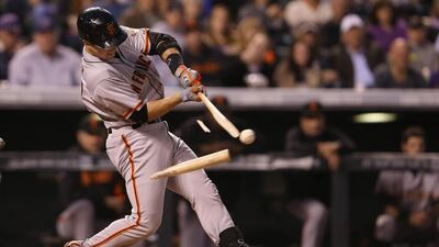 Buster Posey #28 of the San Francisco Giants breaks his bat as he hits into a double play and collects an RBI against the Colorado Rockies in the third inning at Coors Field in Denver, Colorado. Doug Pensinger / Getty