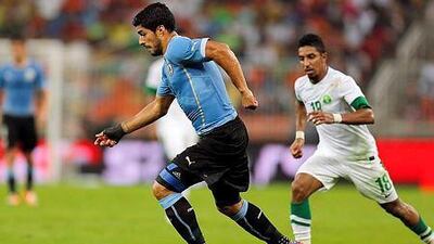 Uruguayan football player Luis Suarez, left, runs with the ball past Saudi Arabia's Salem Al Dawsari during their friendly football match at King Abdullah stadium in Jeddah October 10, 2014. AFP PHOTO/STR