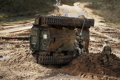 Soldiers secure cables to recover an overturned battle tank during the Royal Electrical & Mechanical Engineers’ Exercise called "Iron Challenge" in the UK. AFP