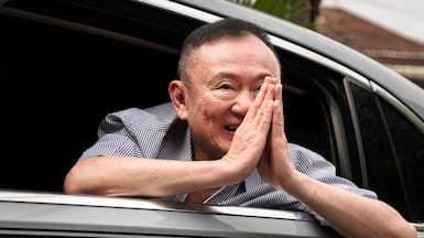 Thaksin Shinawatra gestures as he arrives at his residency in a car after his release from Klong Prem Central Prison in Bangkok. AFP