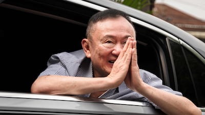 Thaksin Shinawatra gestures as he arrives at his residency in a car after his release from Klong Prem Central Prison in Bangkok. AFP