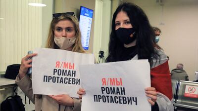 Women stand with posters reading 'I am, we are Roman Protasevich' in the arrival area as passengers disembark at the airport in Vilnius, its initial destination. AFP