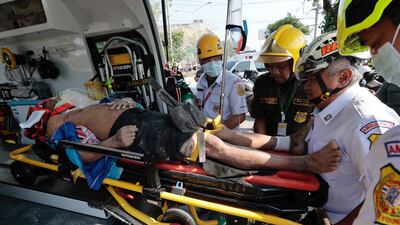 Rescuers place a wounded person onto an ambulance in Bangkok. AP